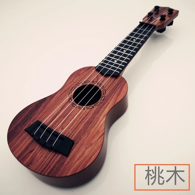 The children's small guitar is a toy that can play a medium-sized ukulele, a beginner's instrument, and comes with a pick for music details Picture