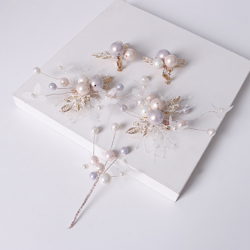 A pair of hair accessories featuring ethereal sequins, twisted silk, pink pearl hair clips, ear clips, fishing nets, and small white flower branches details Picture