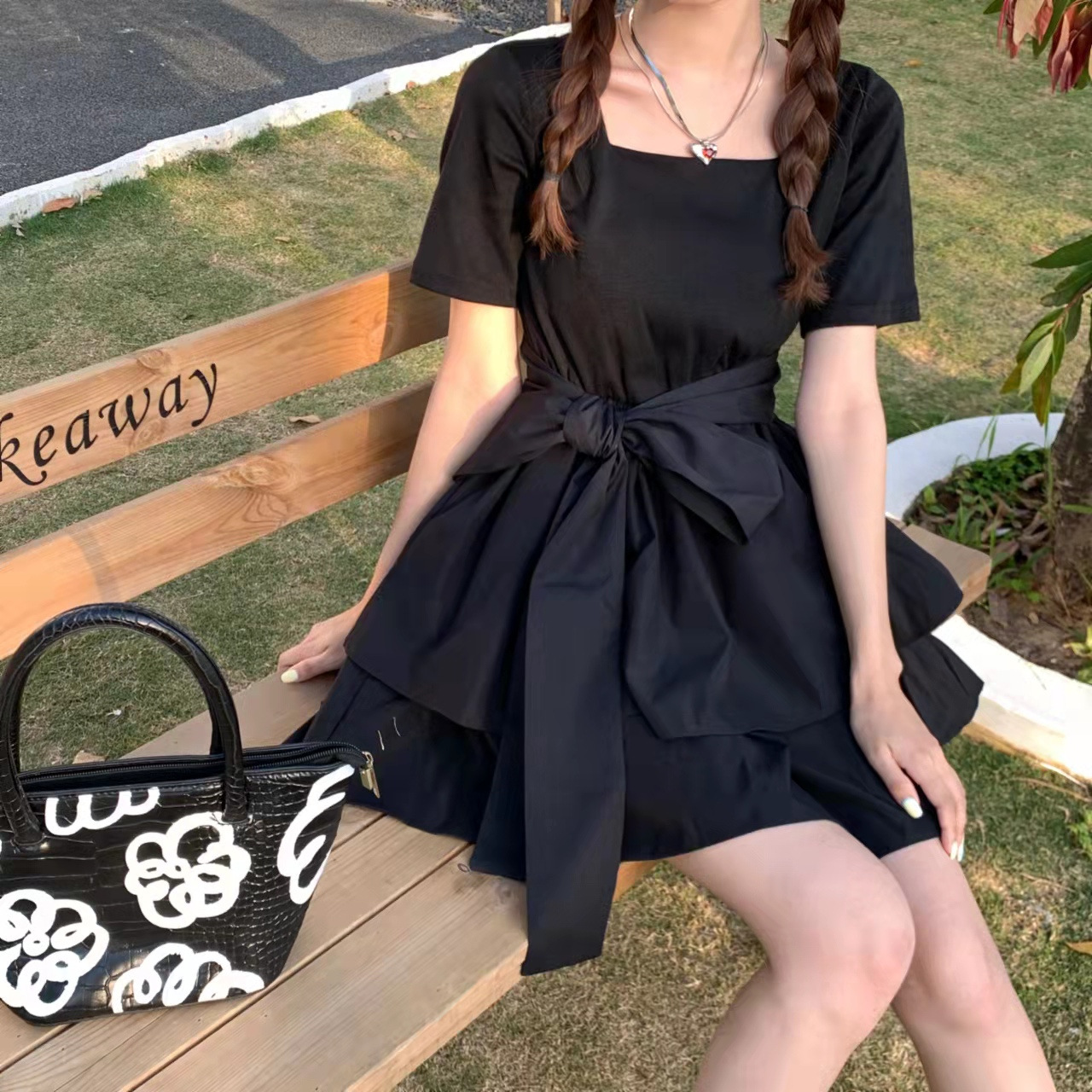 The new summer dress features a French Herben style with a slimming and elegant appearance. It is a trendy short-sleeved pleated dress with a bow tie and a cinched waist