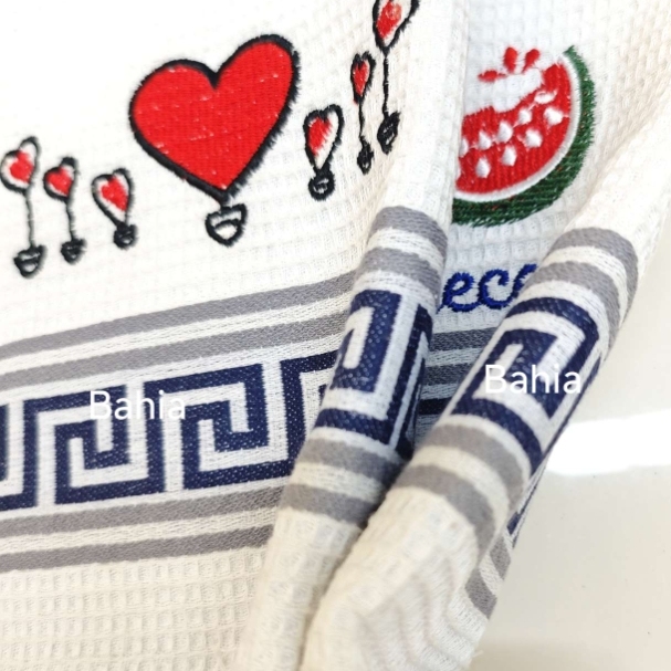 A white cotton tea towel with distinctive blue and grey woven stripes and embroidered patterns