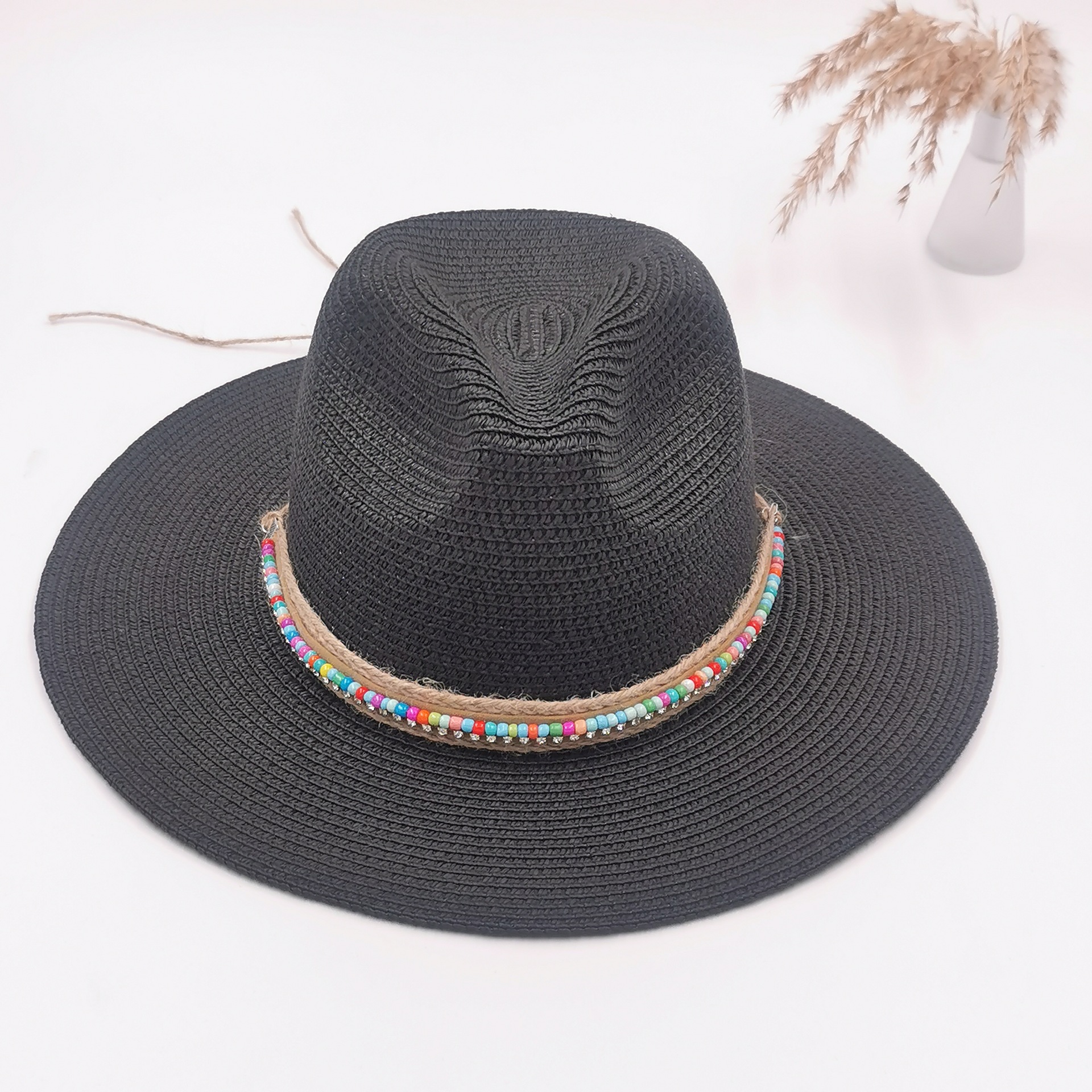 The black wide-brimmed straw hat is a breathable, comfortable and UV-resistant baseball cap
