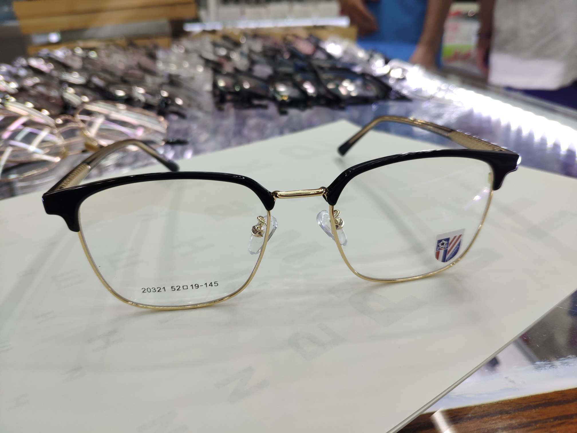 Square-framed black gold-rimmed spectacle frame