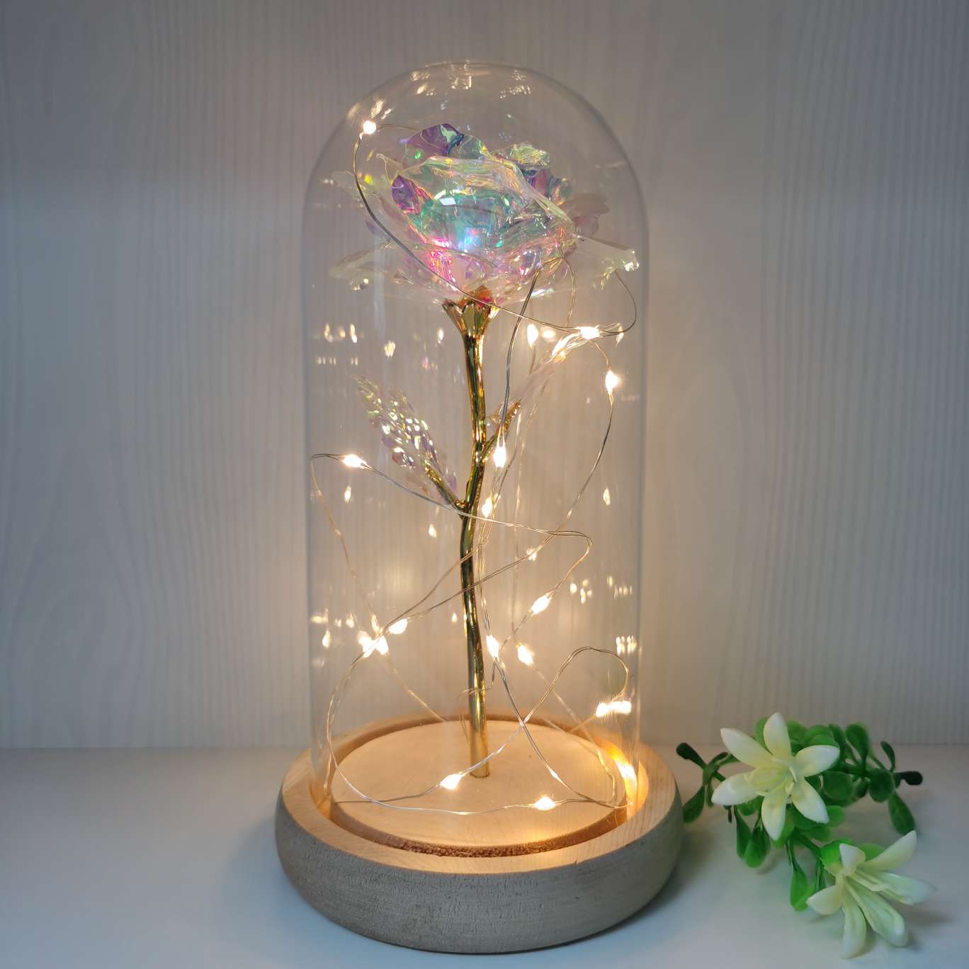 A decorative item with a glass cover and a solid wood base, featuring golden rose petals details Picture