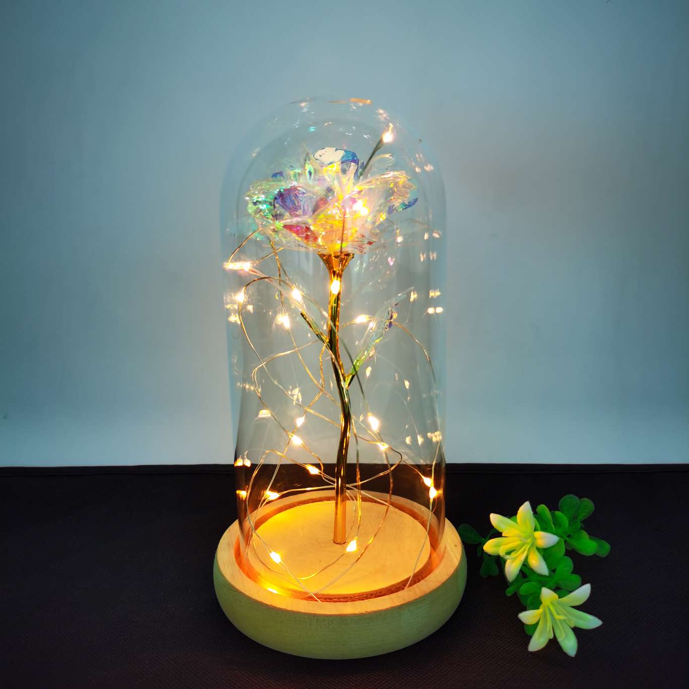 A decorative item with a glass cover and a solid wood base, featuring golden rose petals Item Picture