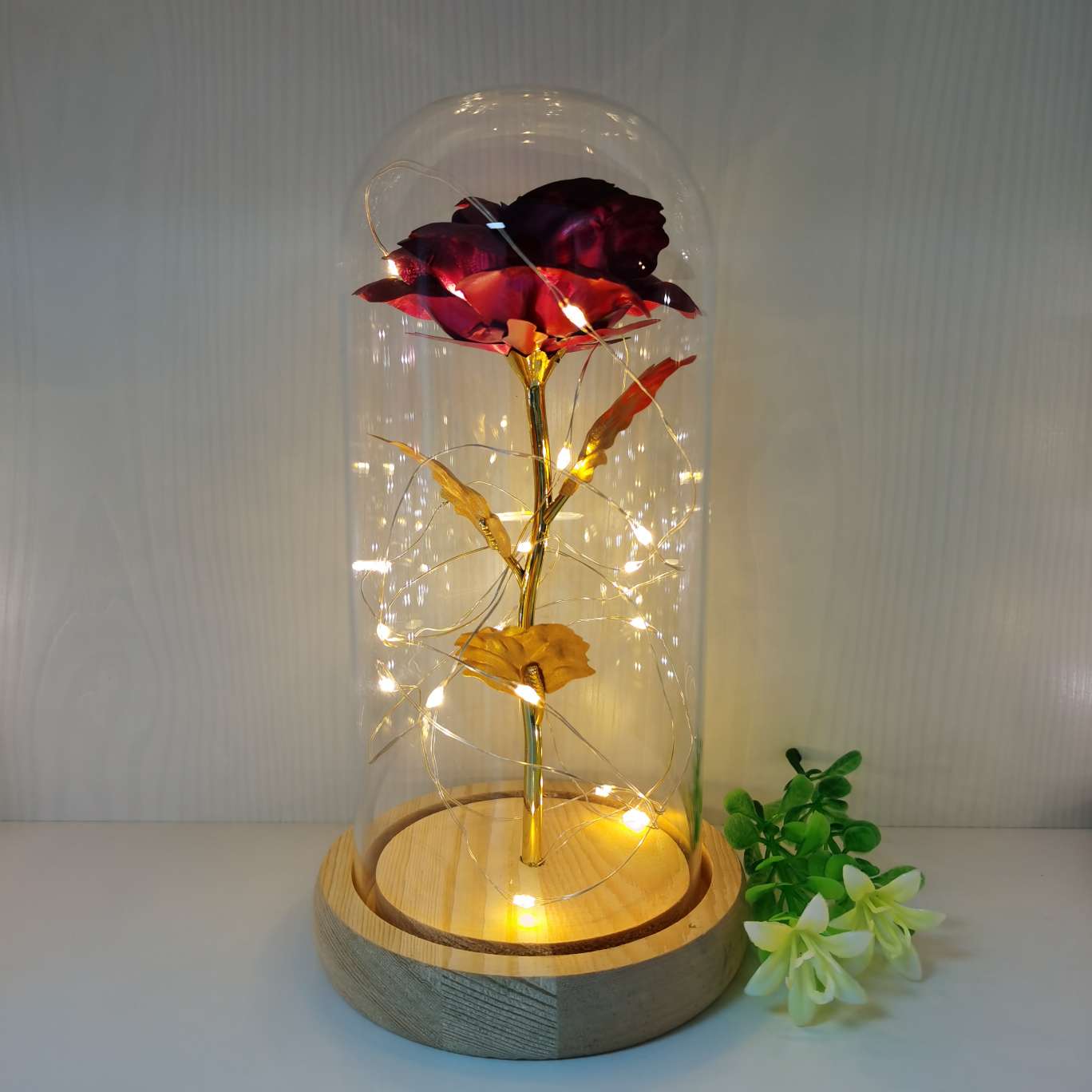 A decorative item with a glass cover and a solid wood base, featuring golden rose petals Specification image