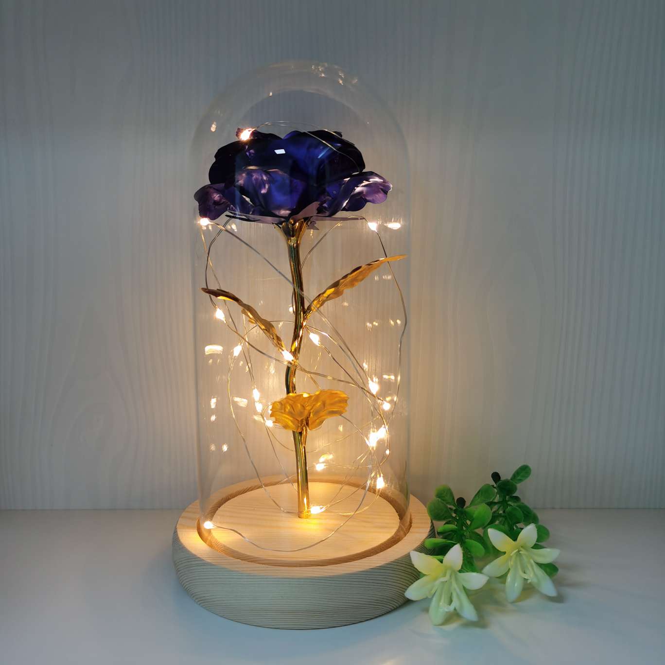 A decorative item with a glass cover and a solid wood base, featuring golden rose petals Application Scenario