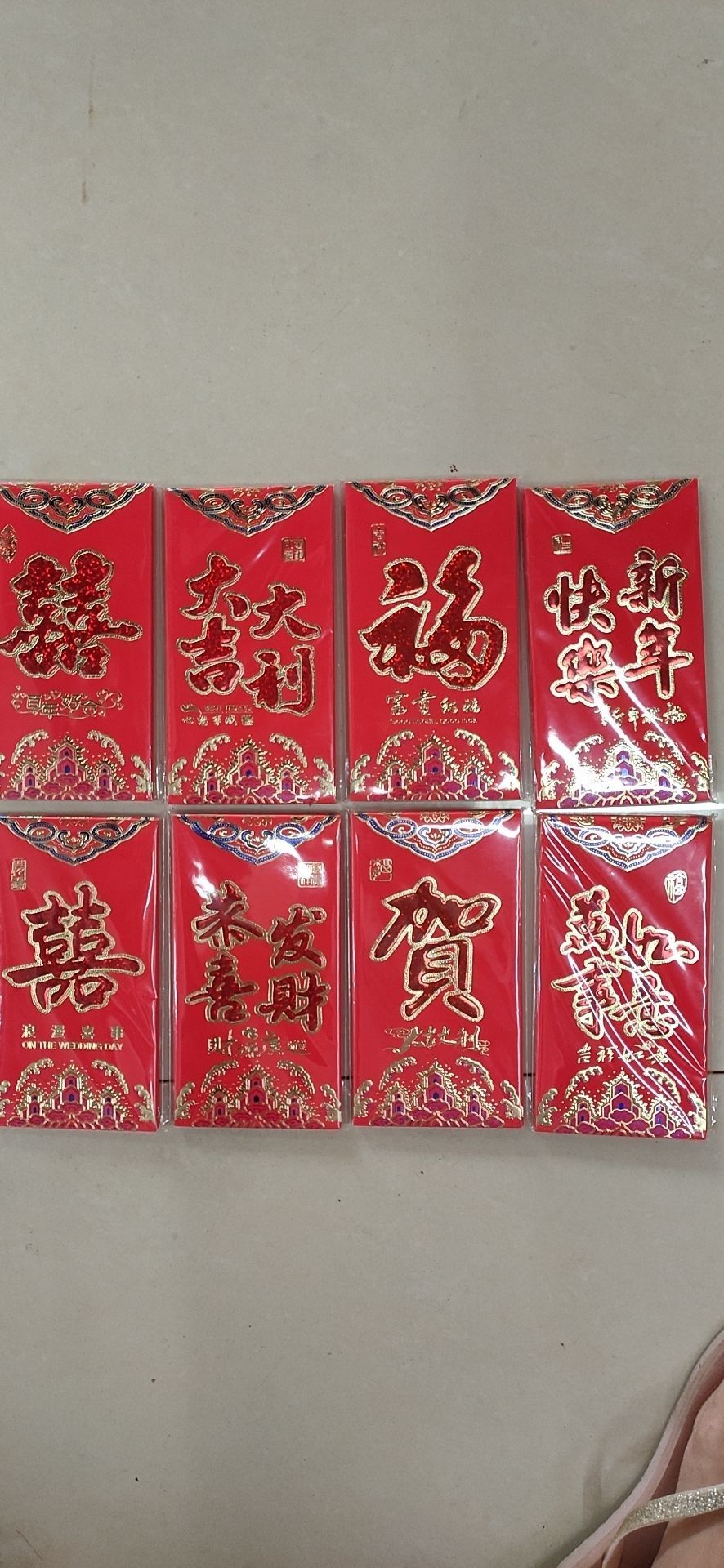 Red envelopes with the character "Fu" for good luck and prosperity. Please stick the "Happy New Year" and "All the best" on the three-color red envelopes