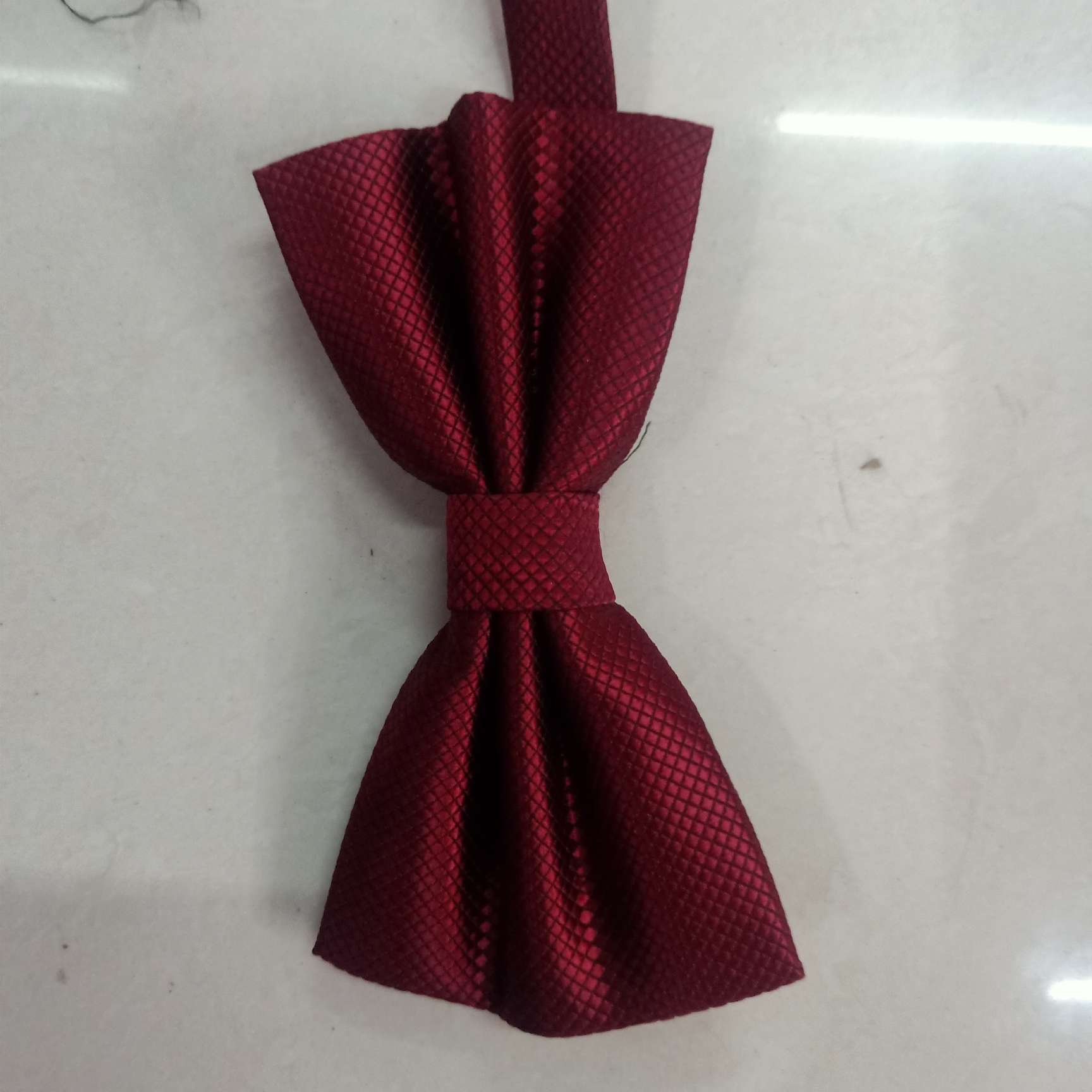 The small checkered bow tie is deep red
