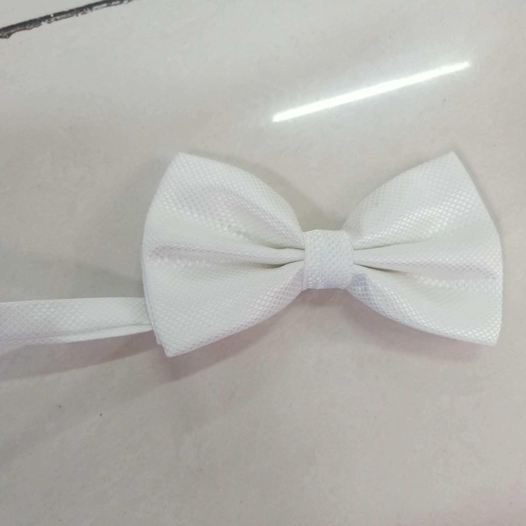 The small checkered bow tie is white