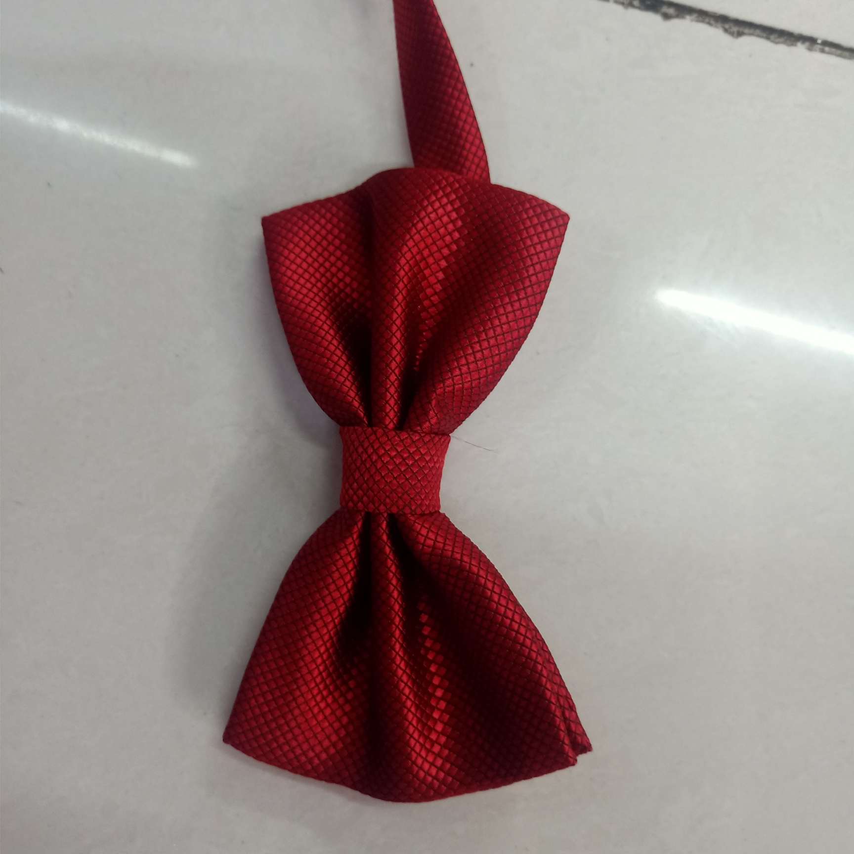 The small checkered bow tie is dark red details Picture