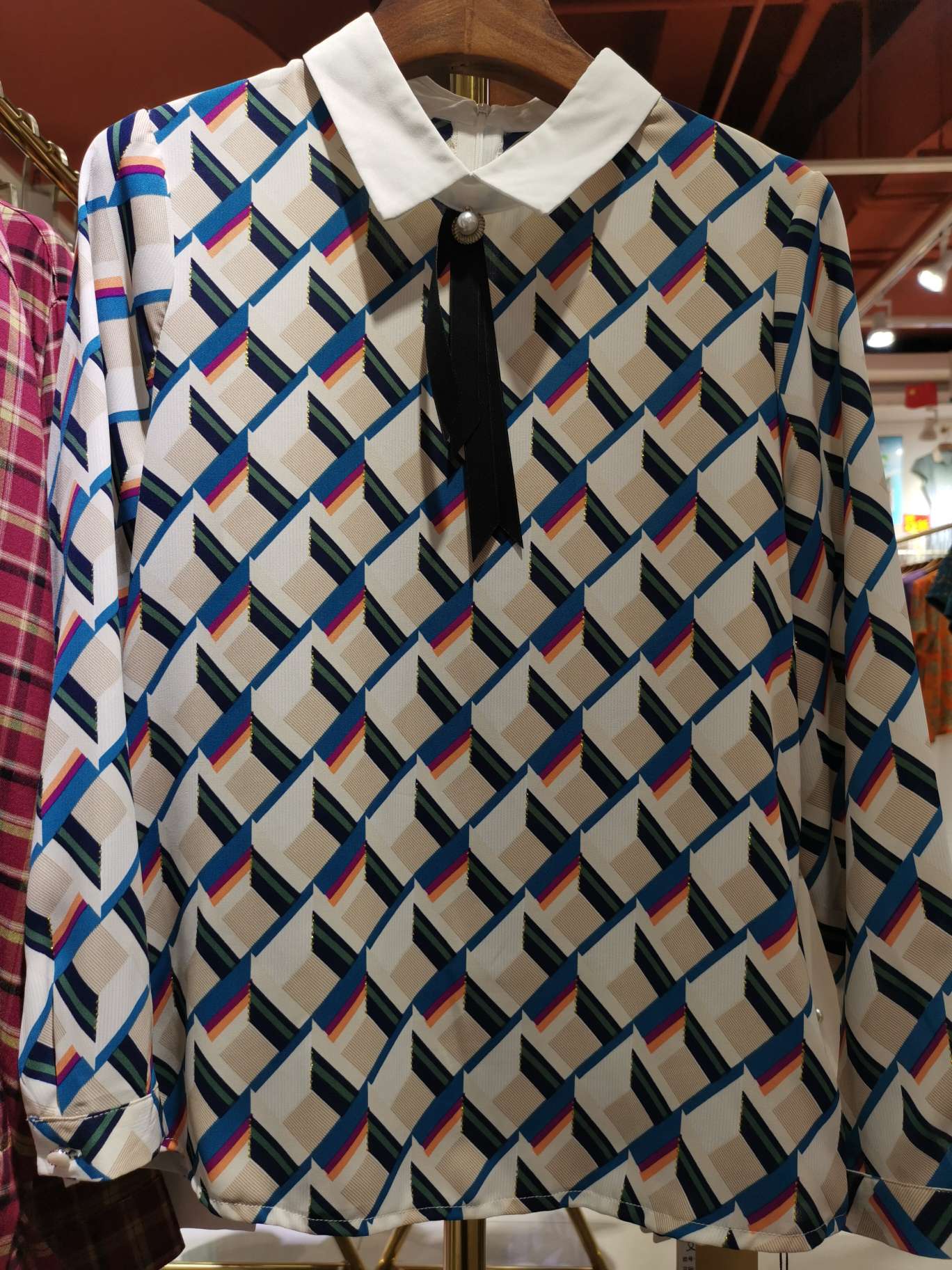 A long-sleeved women's top with a white feather collar and floral pattern