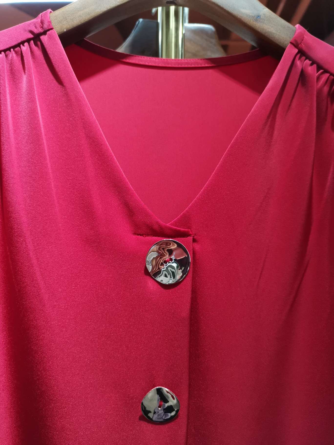 A fashionable long-sleeved women's top with a bright red V-neck and double buttons details Picture