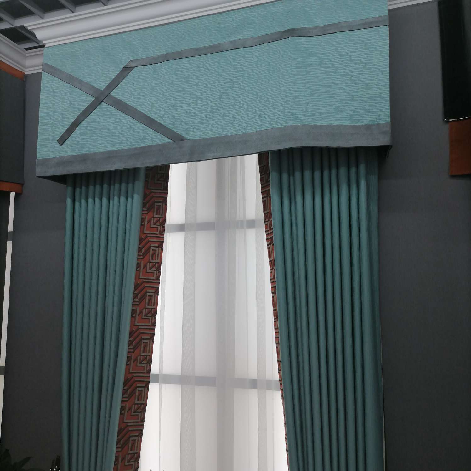 The blue and grey patchwork of the linen curtain fabric