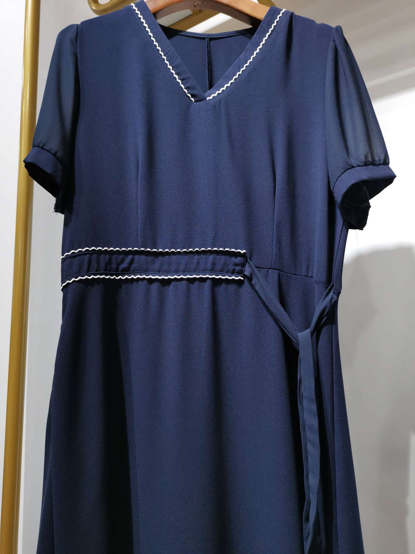 A fashionable V-neck cinched women's dress in bright blue with clear lines