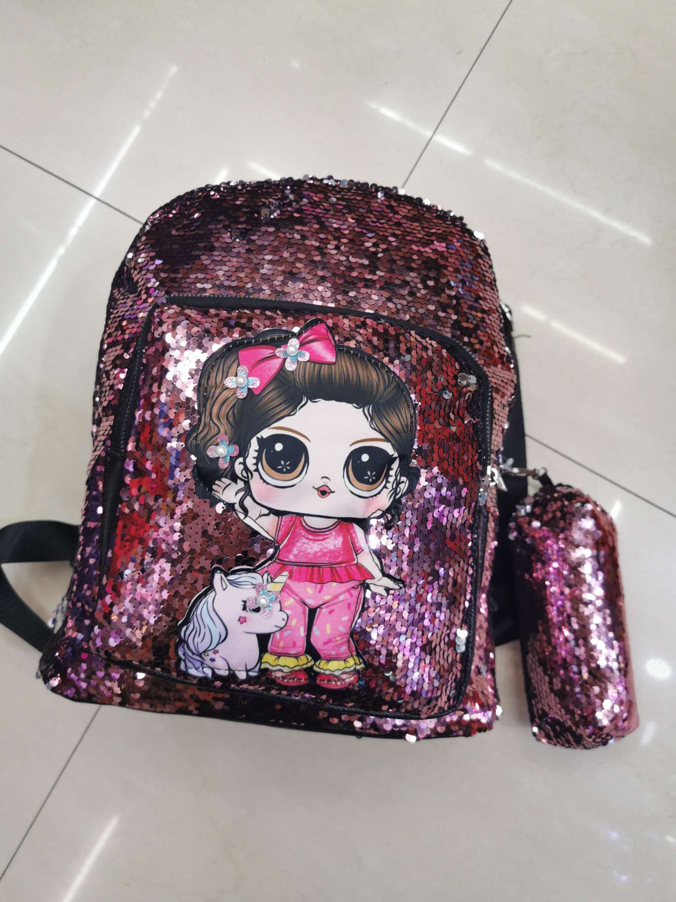 A large pink sequined doll bag