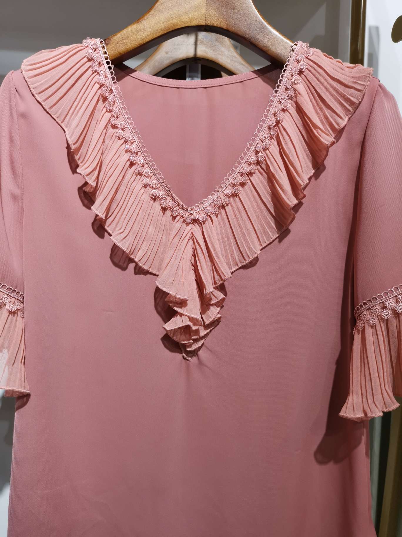 A pink women's top with a fashionable diamond V-shaped lace collar