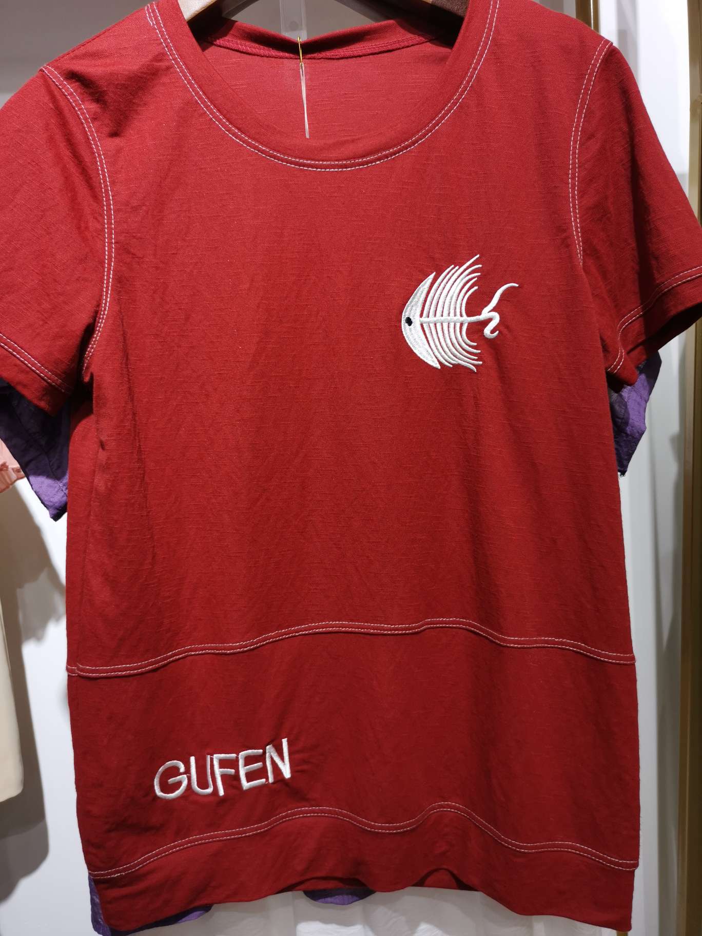 A fashionable business women's top in bright red with white thread