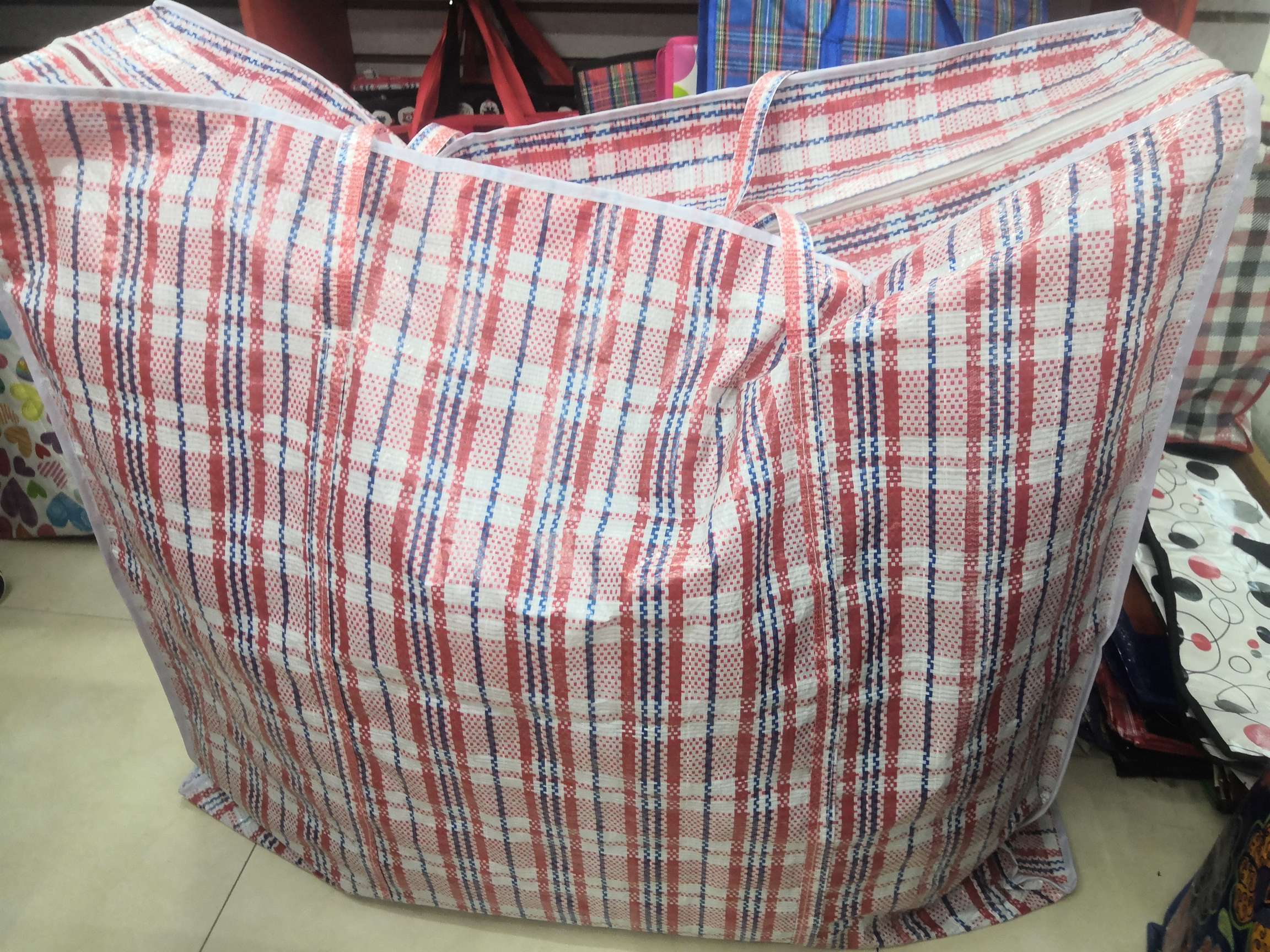 A large red checkered woven bag