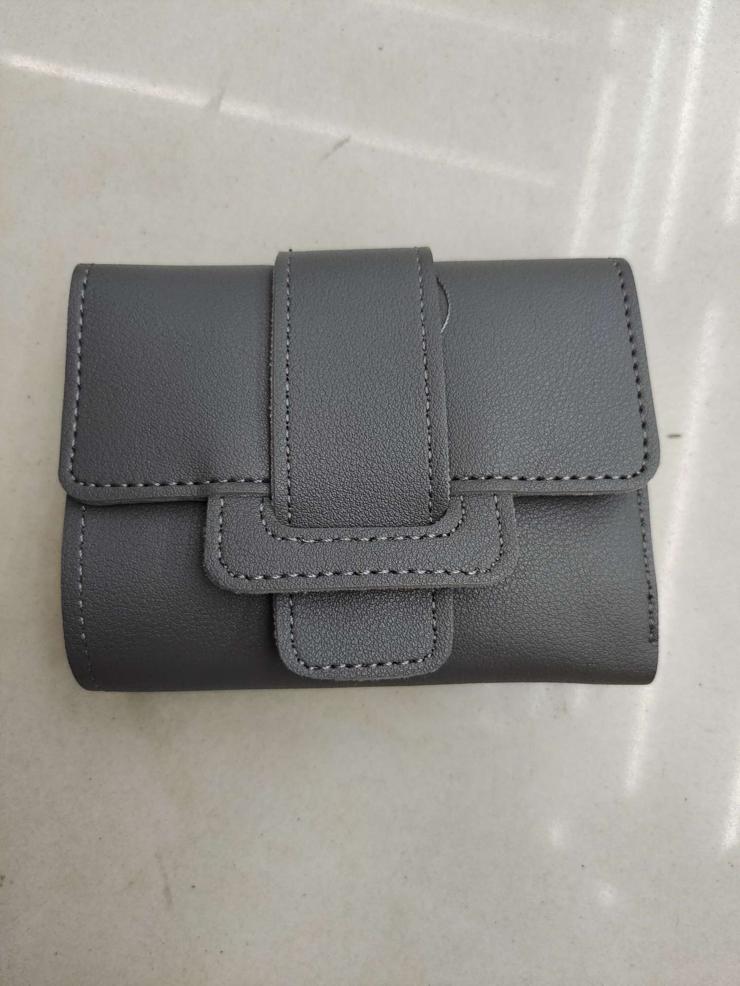 This fashionable short wallet is small, ultra-thin, and features a multi-functional folding soft leather card case with a textured feel