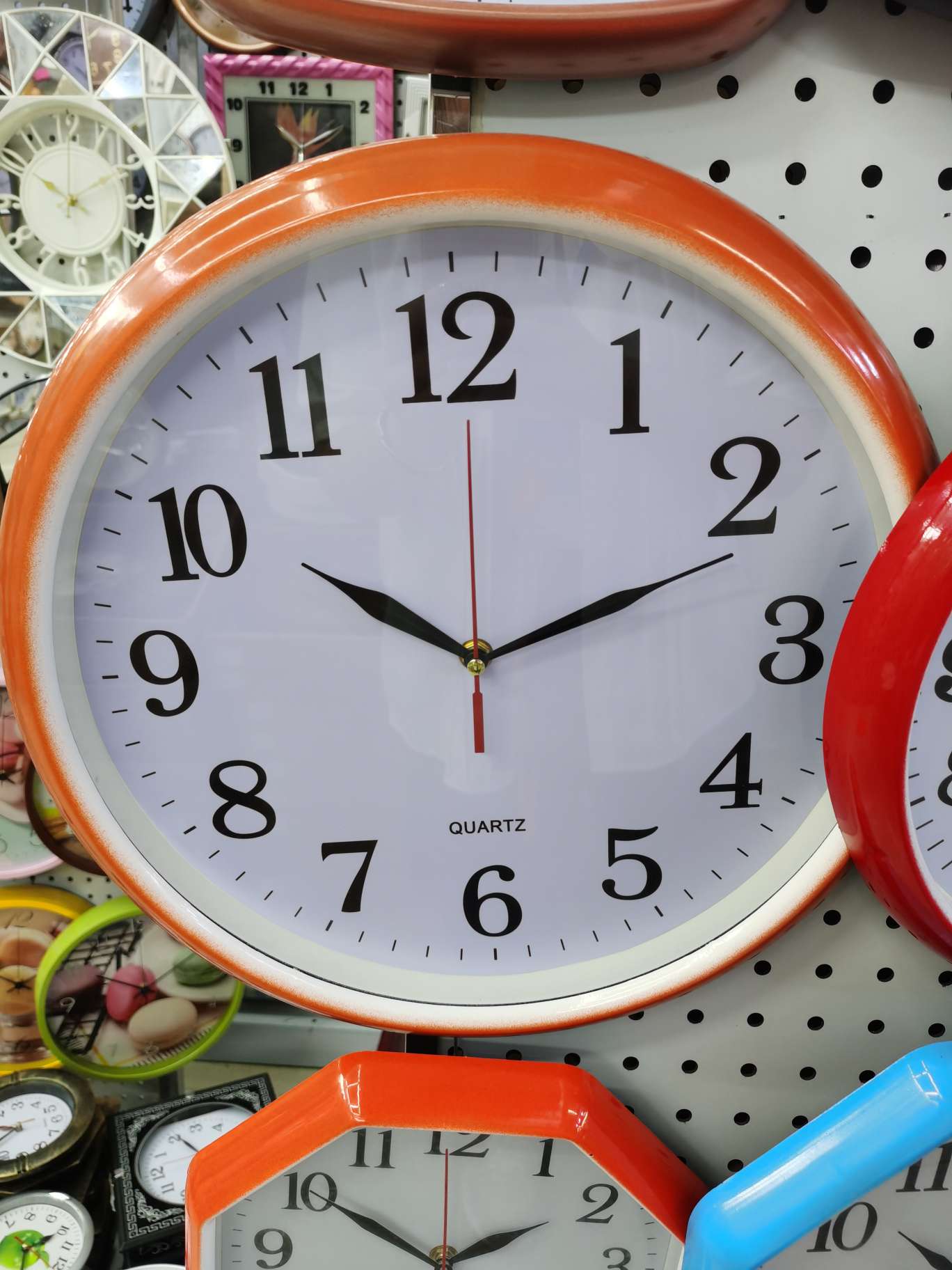 The orange wall clock is simple and elegant