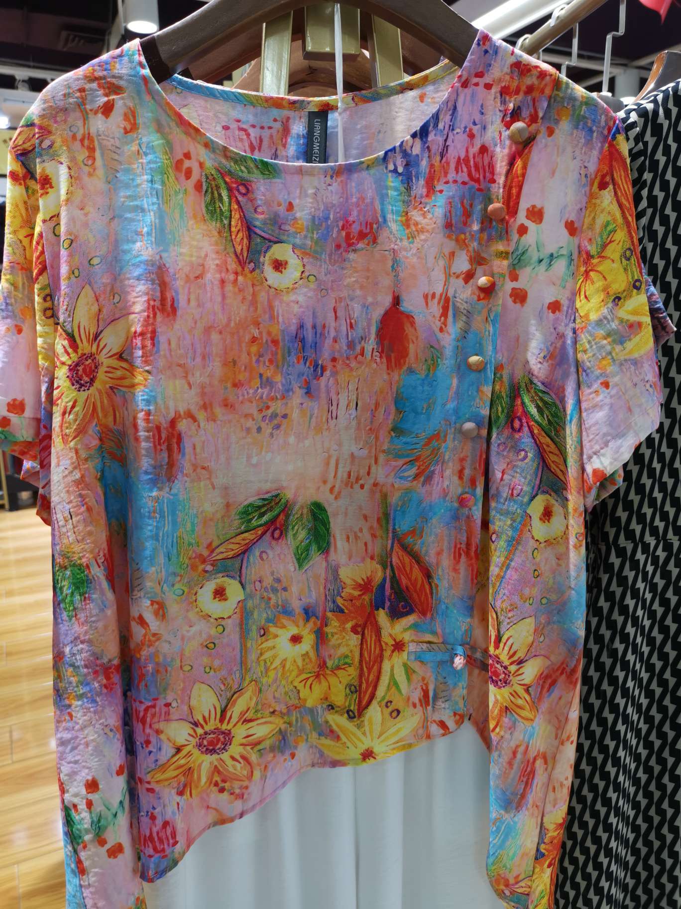 A fashionable mid-sleeved women's shirt with a large round neck, bright colors and large flowers
