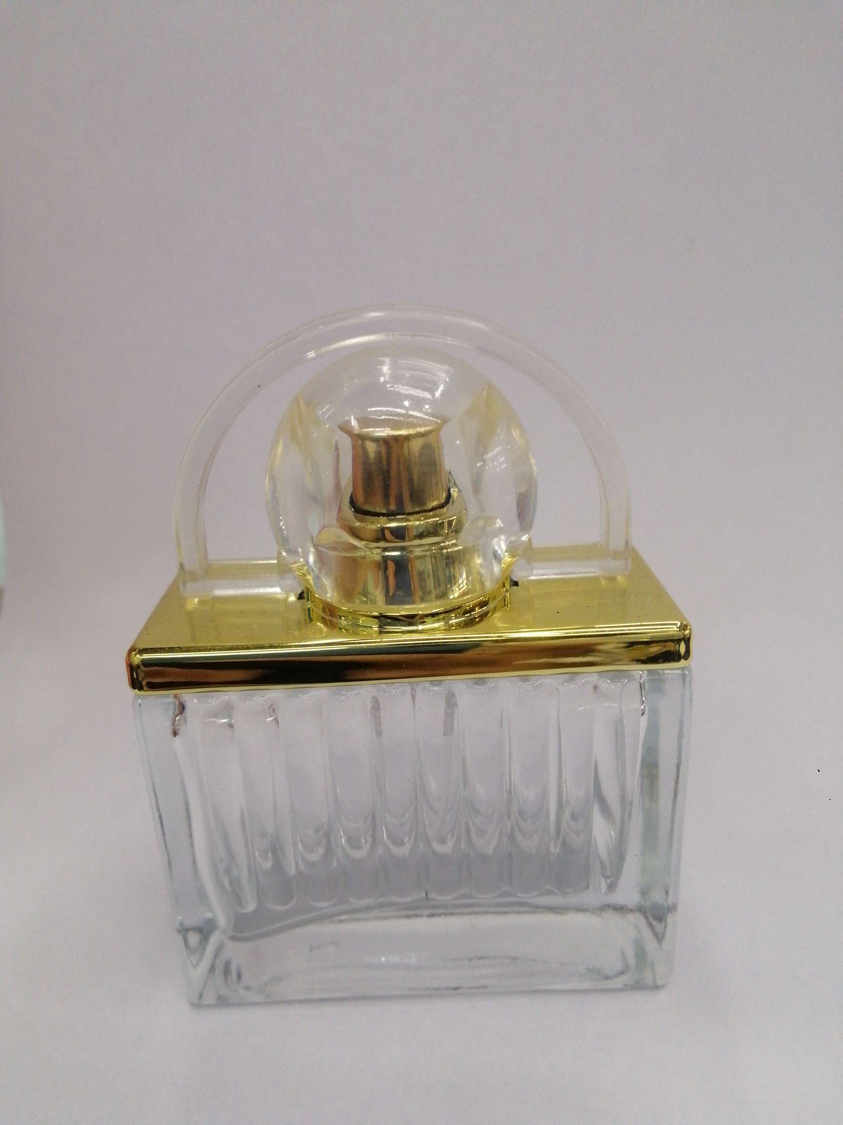 The perfume bottle is golden in glass thumbnail