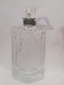 A clear perfume bottle in a glass bottle