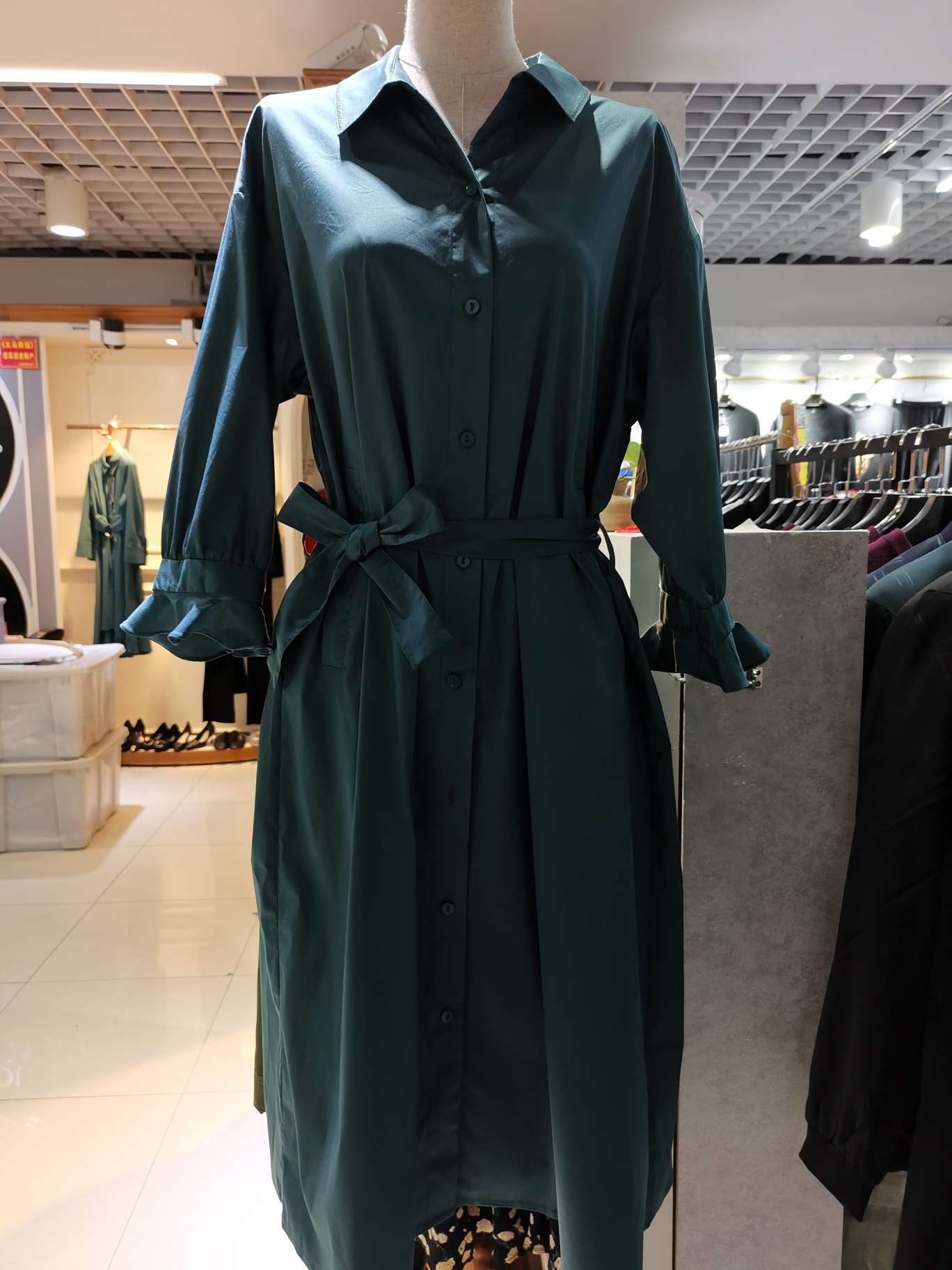 A mid-sleeved women's dress with a cinched waist belt and a suit collar