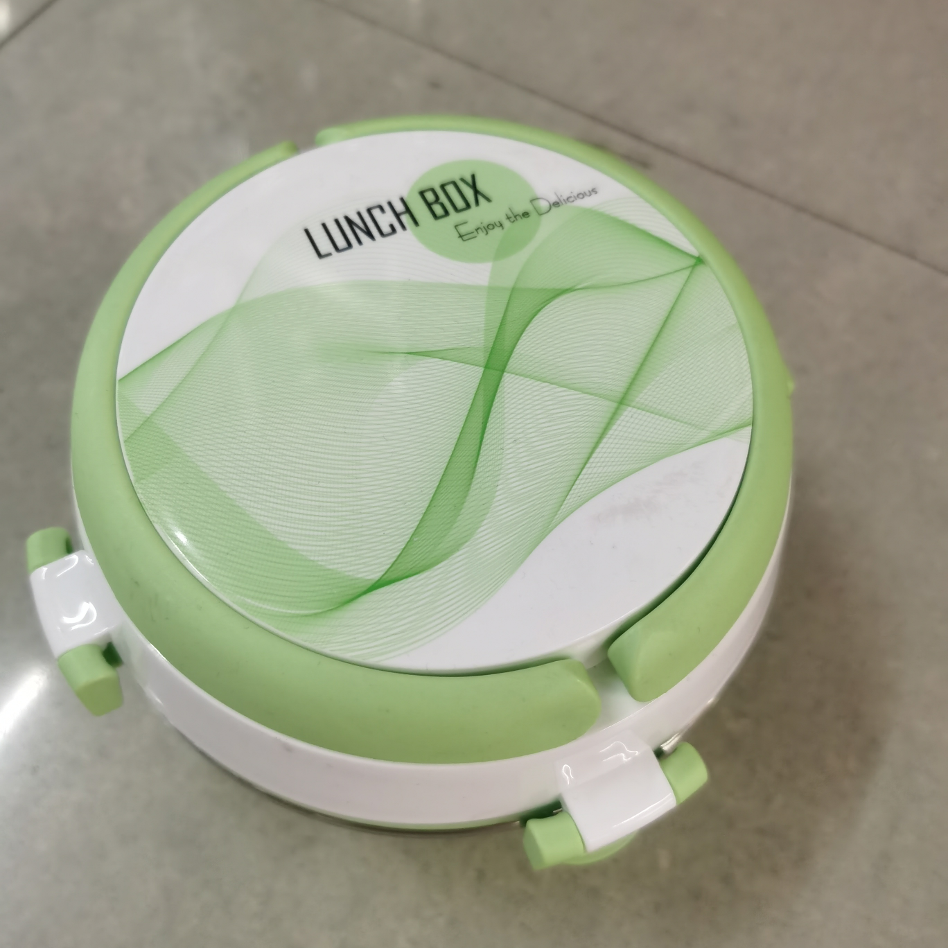 A round lunch box made of plastic, small and compact