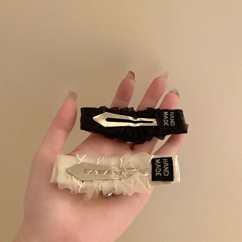 The new Korean pleated heart-shaped bb clip features a stylish side bangs and a black clip with broken hair and pearl hair clip at the back of the head for summer details Picture