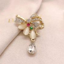 Glass cat's eye fashion brooch with bow