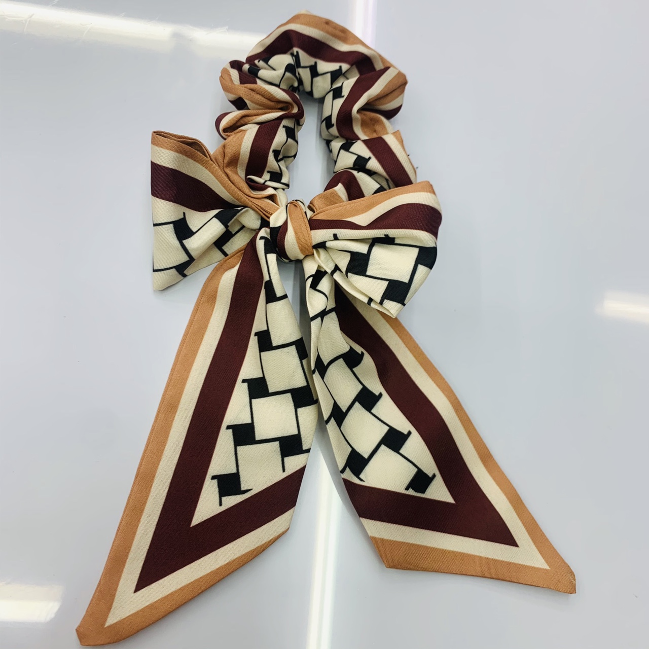 The small ribbon bow tie has a dark red checkered pattern