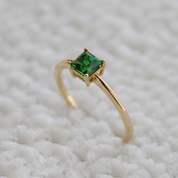 A fashionable square emerald engagement ring slightly studded with diamonds for a simple wedding