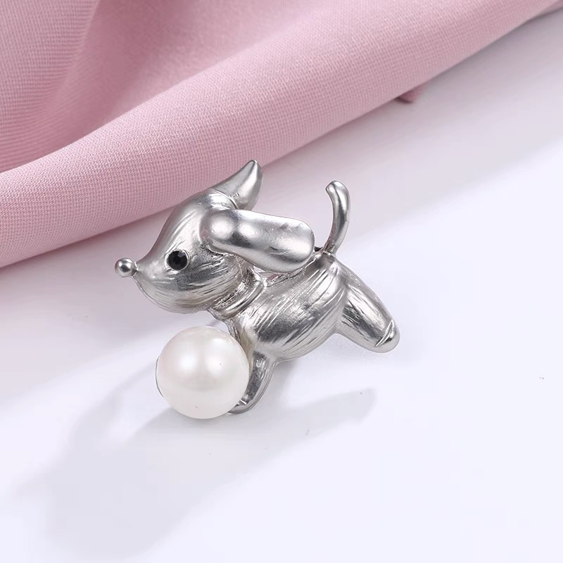 Puppy holding pearl brooch