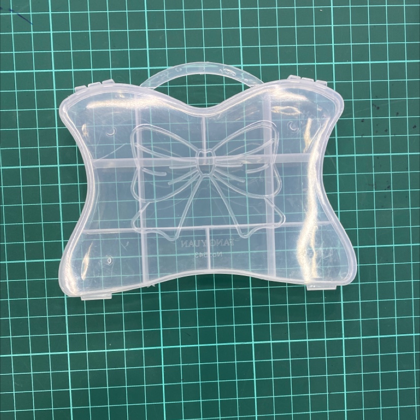 A handbag with a bow in a circular storage box