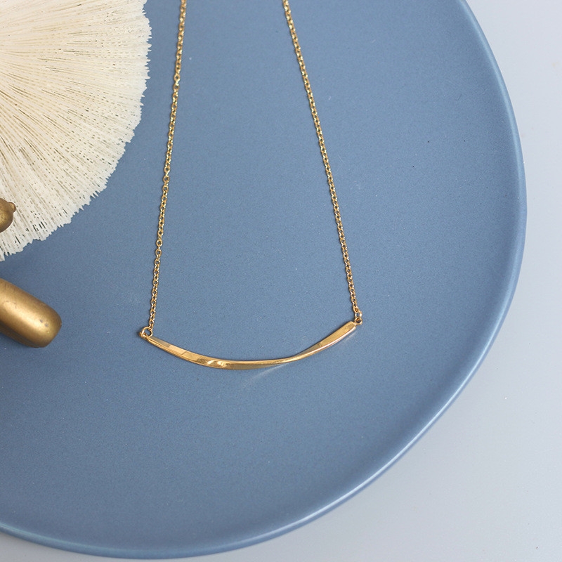 The smiling face necklace features a simple and niche design. It is made of K gold with a twisted smile and a collarbone chain for women