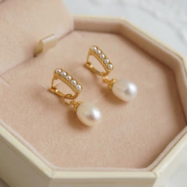 The rectangular ear buckles are inlaid with pearls in the middle and decorated with egg-shaped pearls