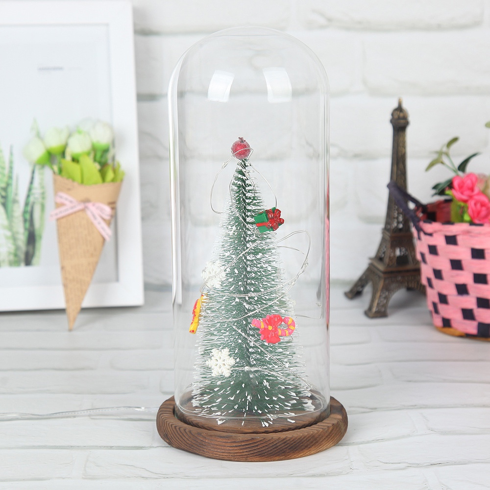 A large artificial Christmas tree with a transparent dust-proof glass cover is a home decoration for the living room and bedroom