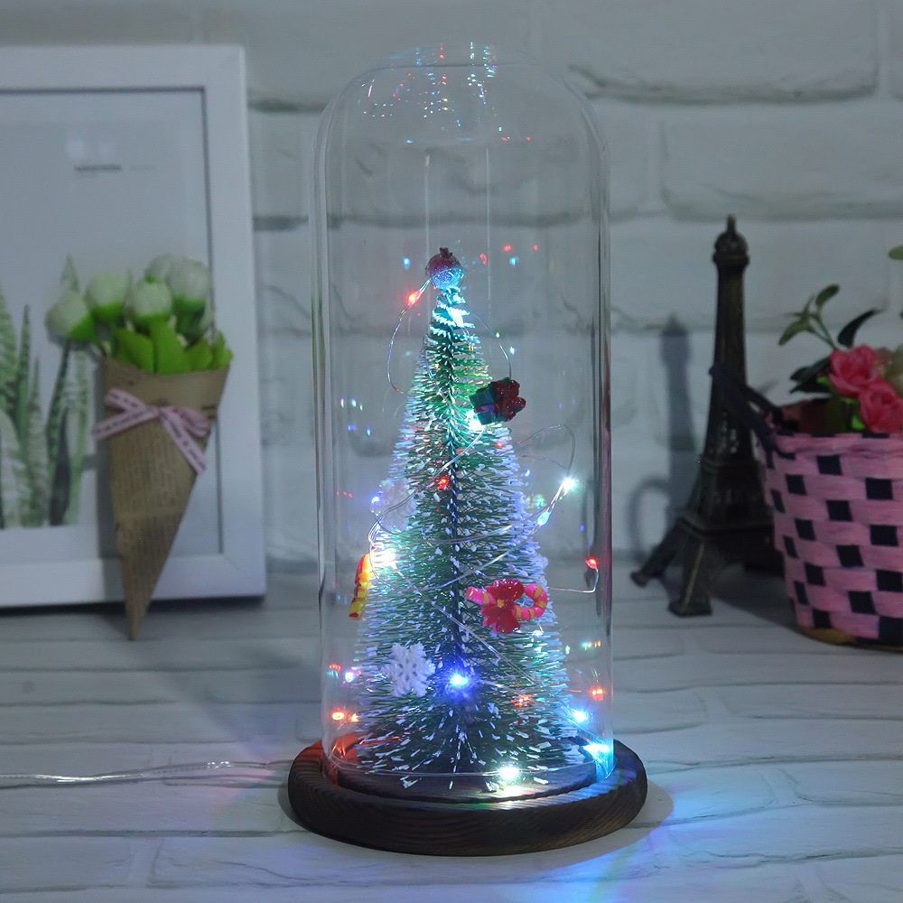 A large artificial Christmas tree with a transparent dust-proof glass cover is a home decoration for the living room and bedroom details Picture