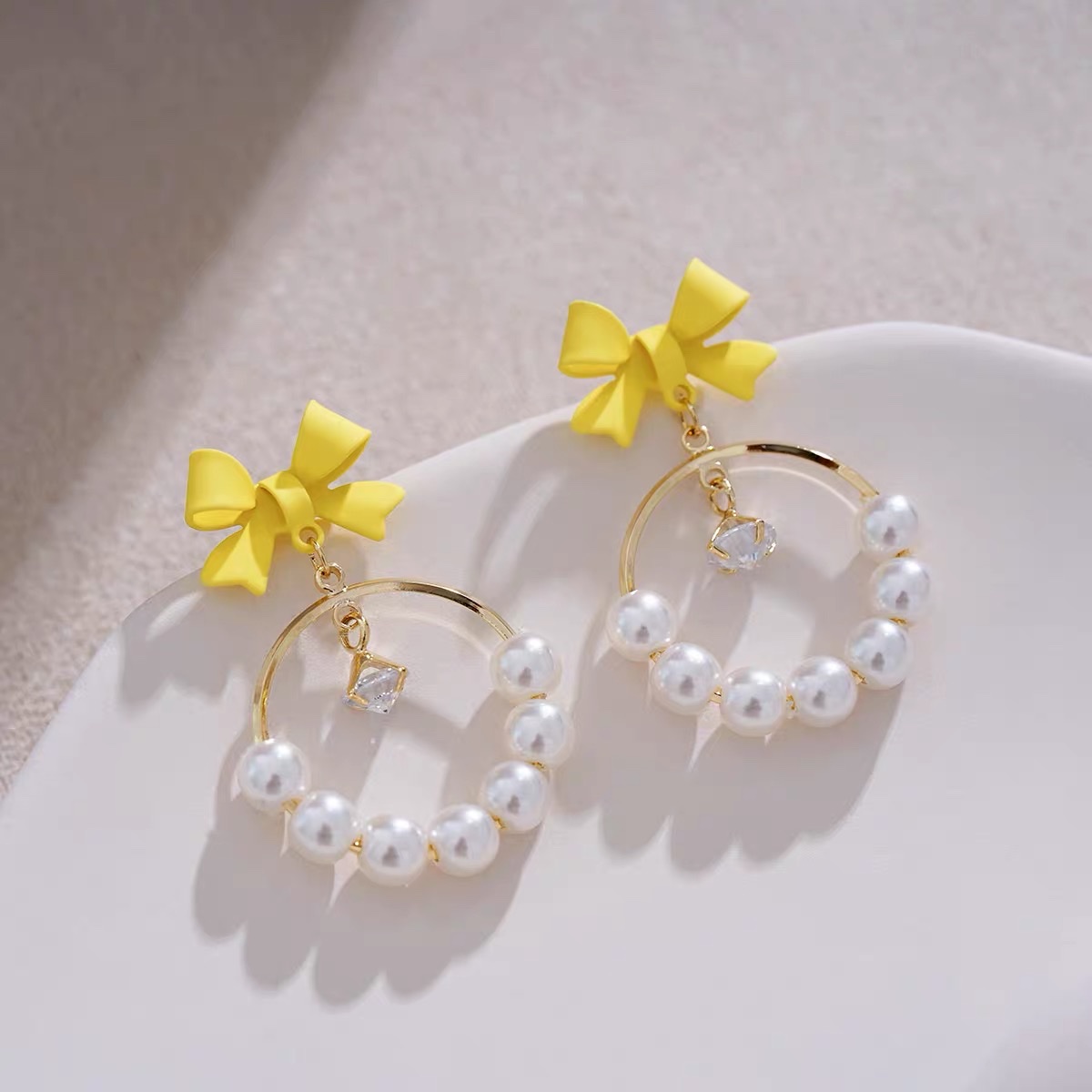 Light yellow bow ear earrings with a unique design sense, French retro and high-end style, Jieya steel jewelry detail image 1