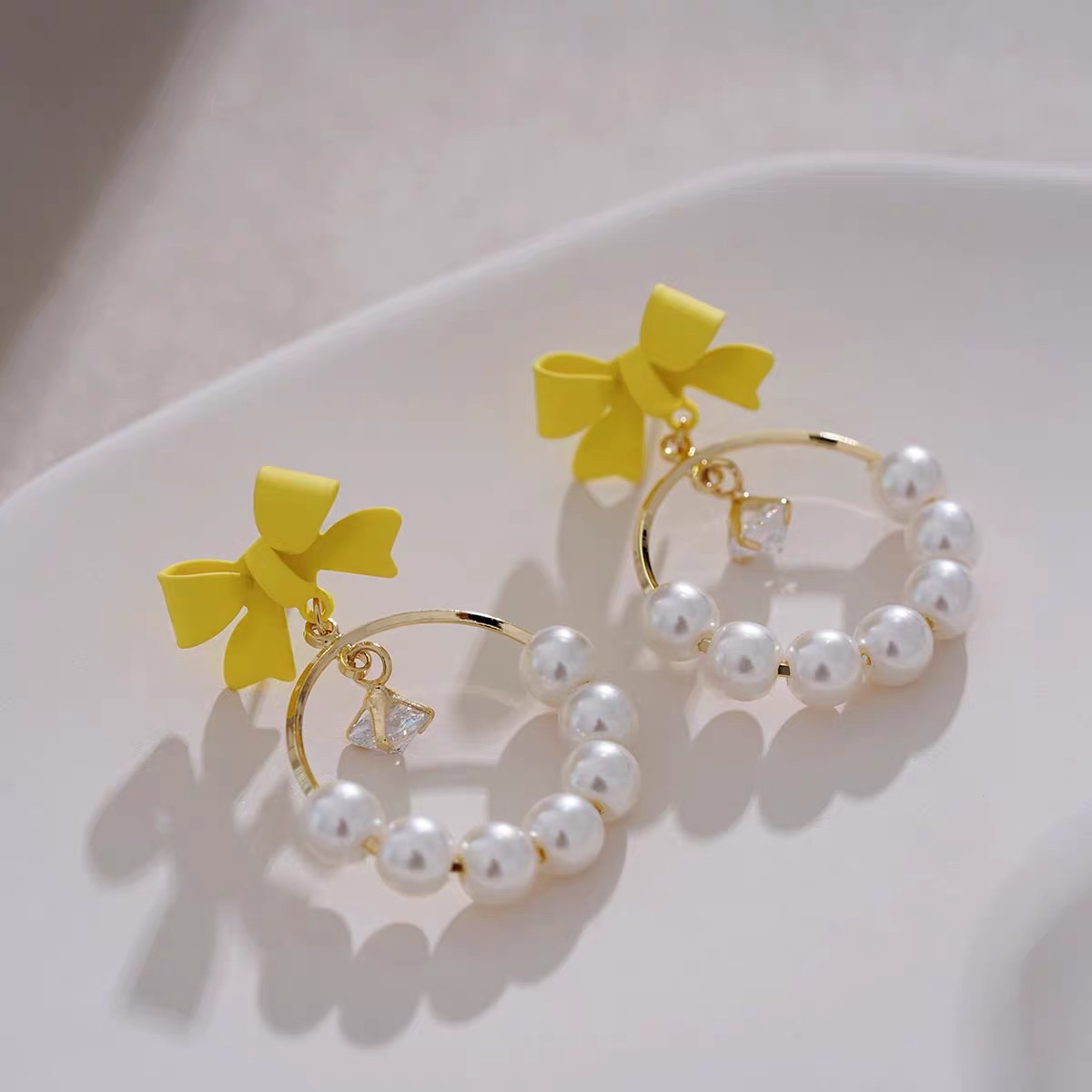 Light yellow bow ear earrings with a unique design sense, French retro and high-end style, Jieya steel jewelry detail image 2