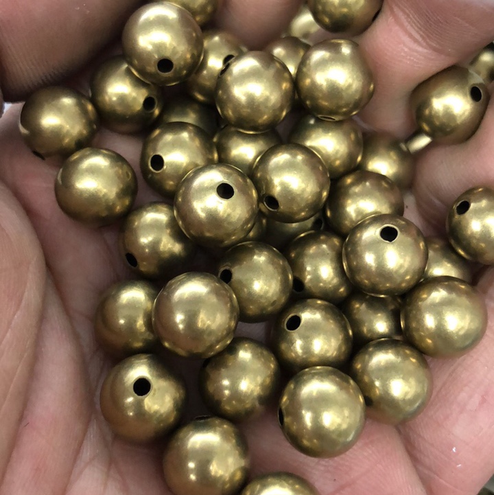 The smooth surface of the copper bead has straight holes