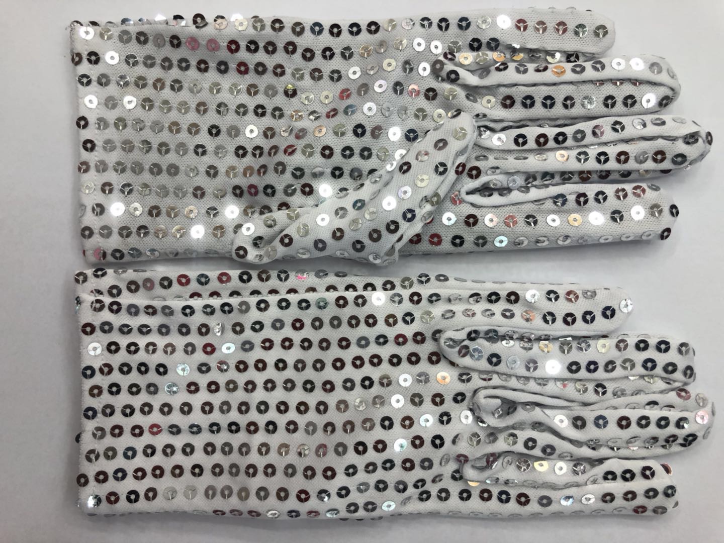 Kids wearing sequin gloves on stage