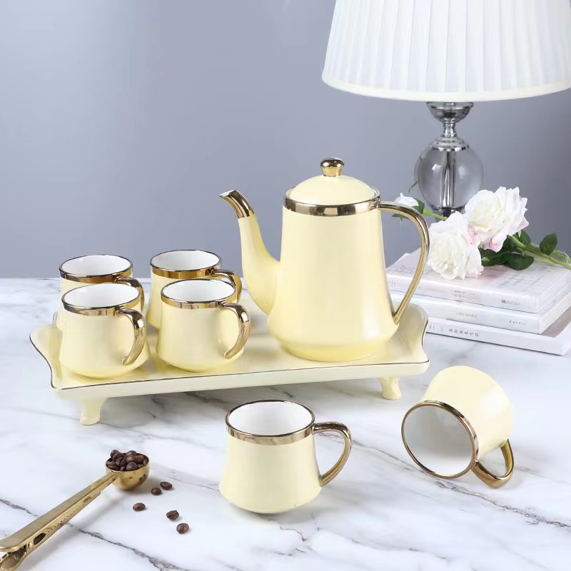 A Yellow Pot Of Six Cups Of Tea Set