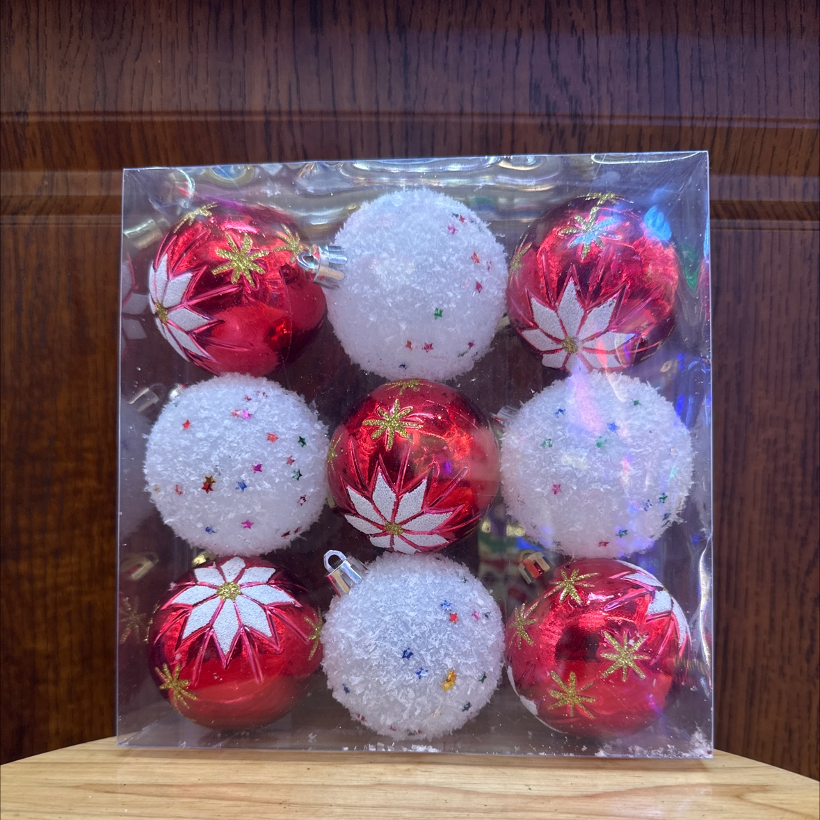 Nine Christmas painted balls in a PVC box