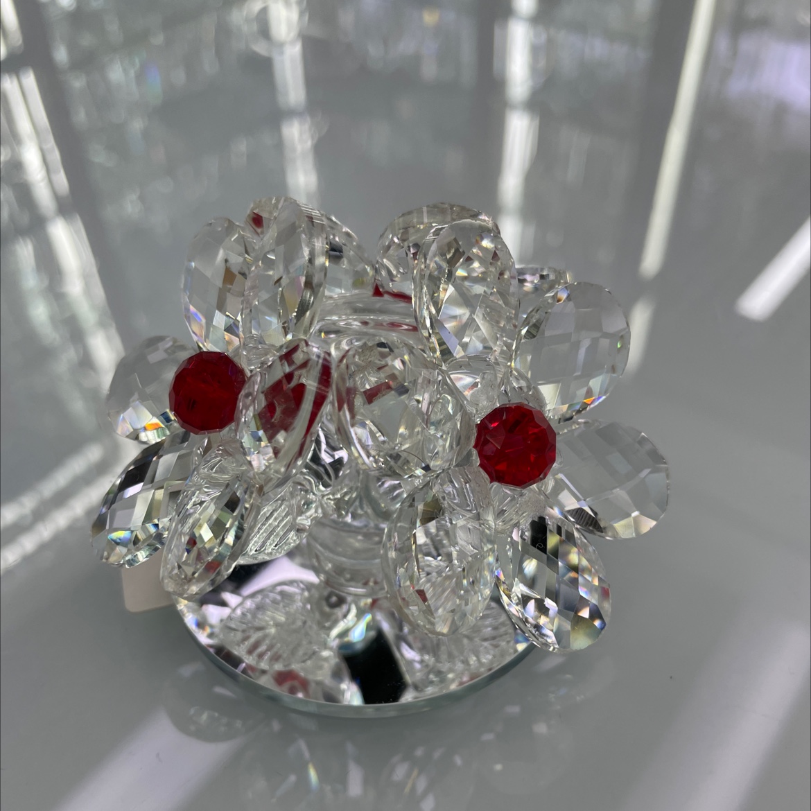 The glass ornament has a base with three flowers, red stamens and white petals, totaling six petals. It is a small and exquisite ornament that is both beautiful and exquisite