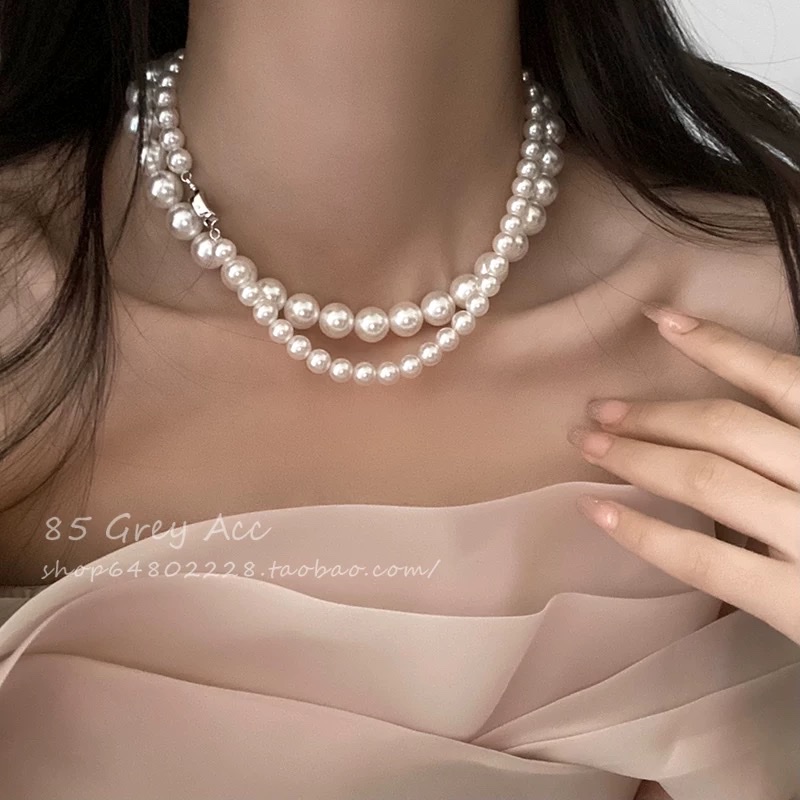 Shi Family Pearl necklace, a unique and light luxury design for women, exudes a sense of sophistication and simplicity. It features a collarbone chain, a gold inlay button, and a sweater chain Item Picture