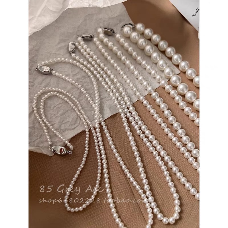 Shi Family Pearl necklace, a unique and light luxury design for women, exudes a sense of sophistication and simplicity. It features a collarbone chain, a gold inlay button, and a sweater chain