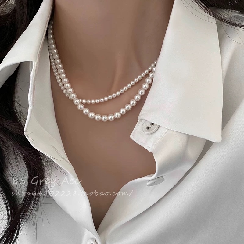 Shi Family Pearl necklace, a unique and light luxury design for women, exudes a sense of sophistication and simplicity. It features a collarbone chain, a gold inlay button, and a sweater chain details Picture