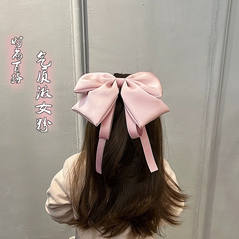 A large bow hairpin for children is stuck on the back of the head of a wine-red little girl princess for the New Year. A ribbon hairband is a cartoon hairband Specification image